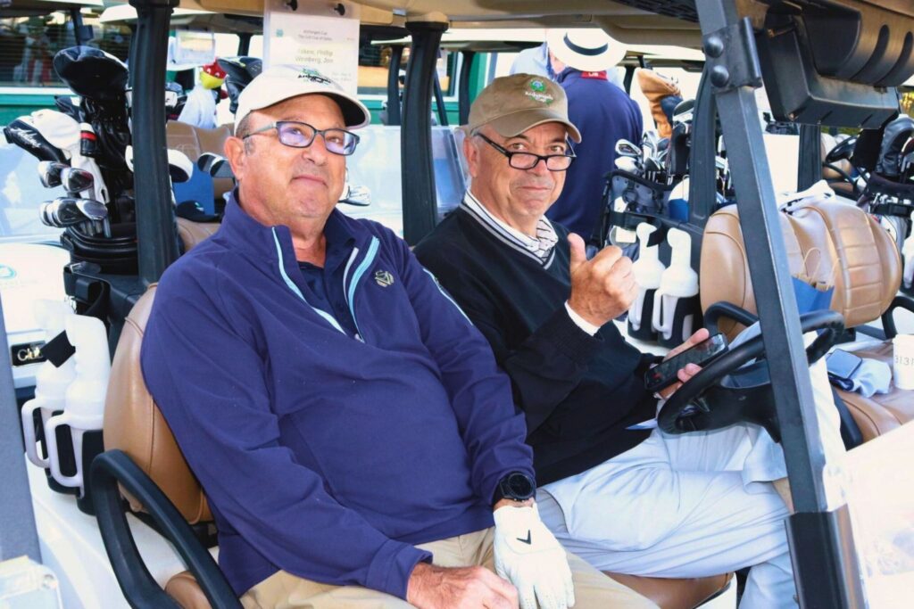 men smiling driving golf cart