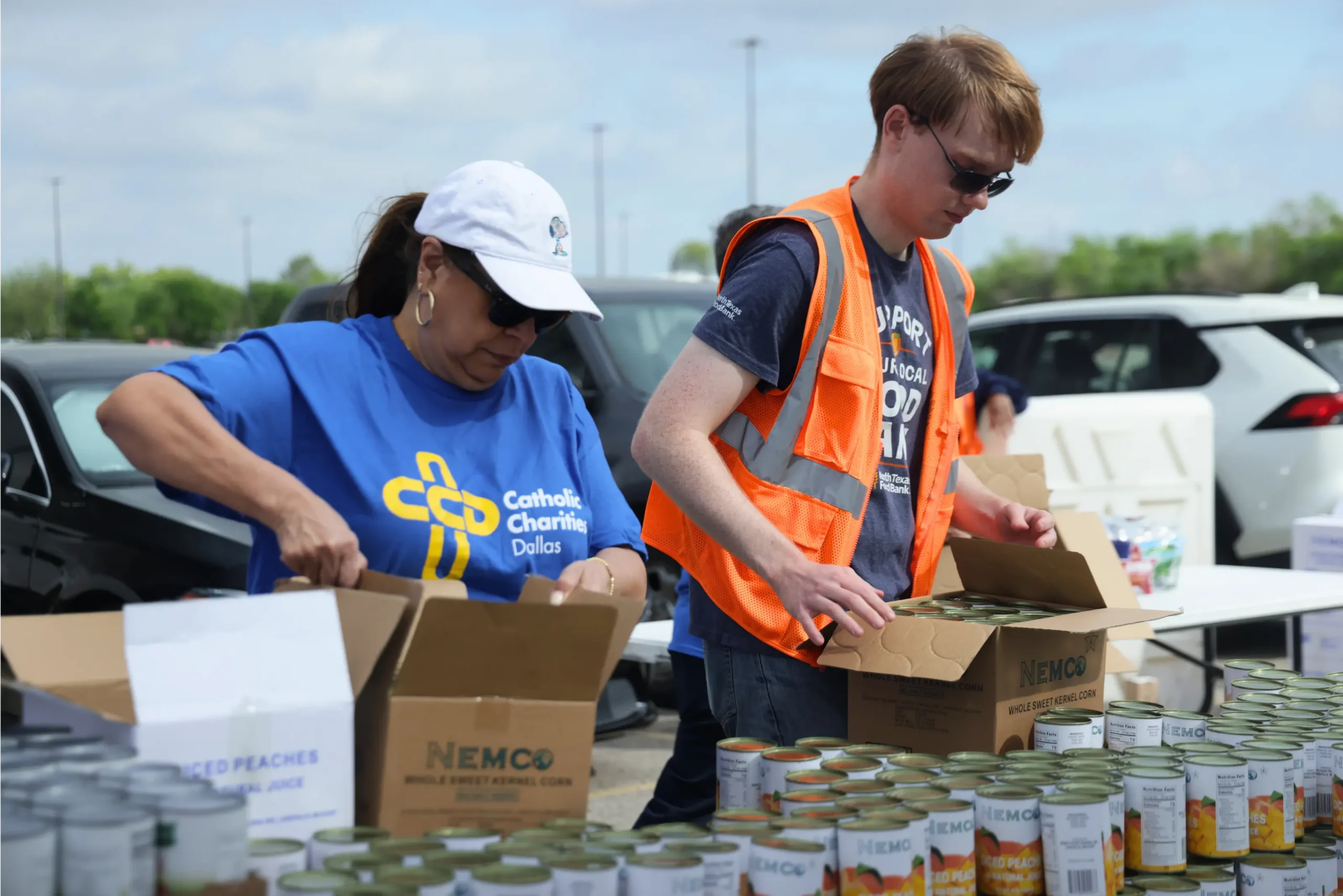 Two serious volunteers from different organizations (CCD and NTFB) organizing food.